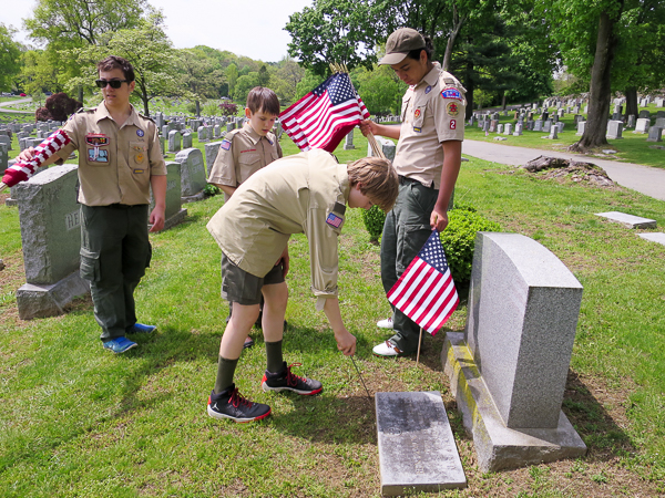 Placing flags for veterans at Mt. Hope Cemetery
